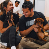 Two guests cuddling mini dachshund puppies during a puppy yoga class at Therapy Puppy Studio